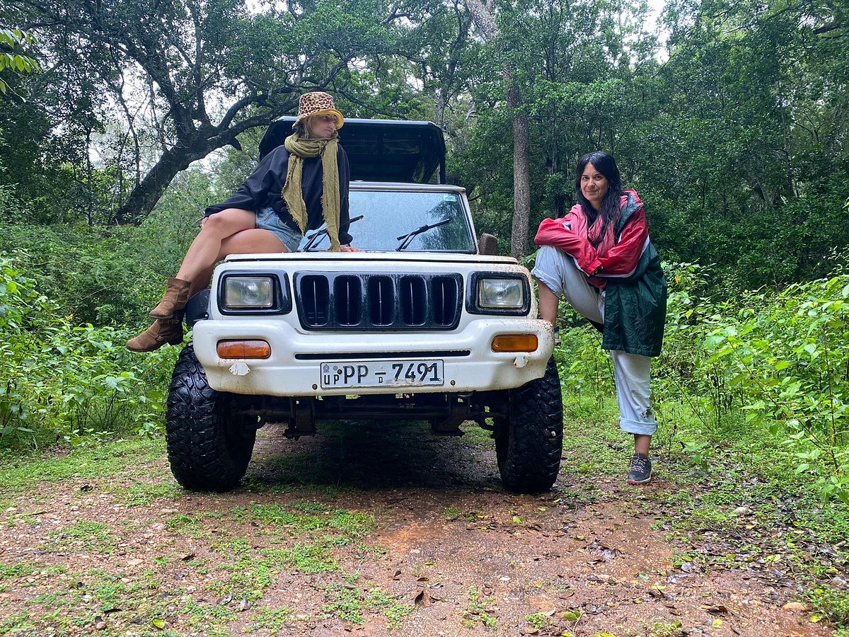 Two travellers posing on the safari jeep bonnet