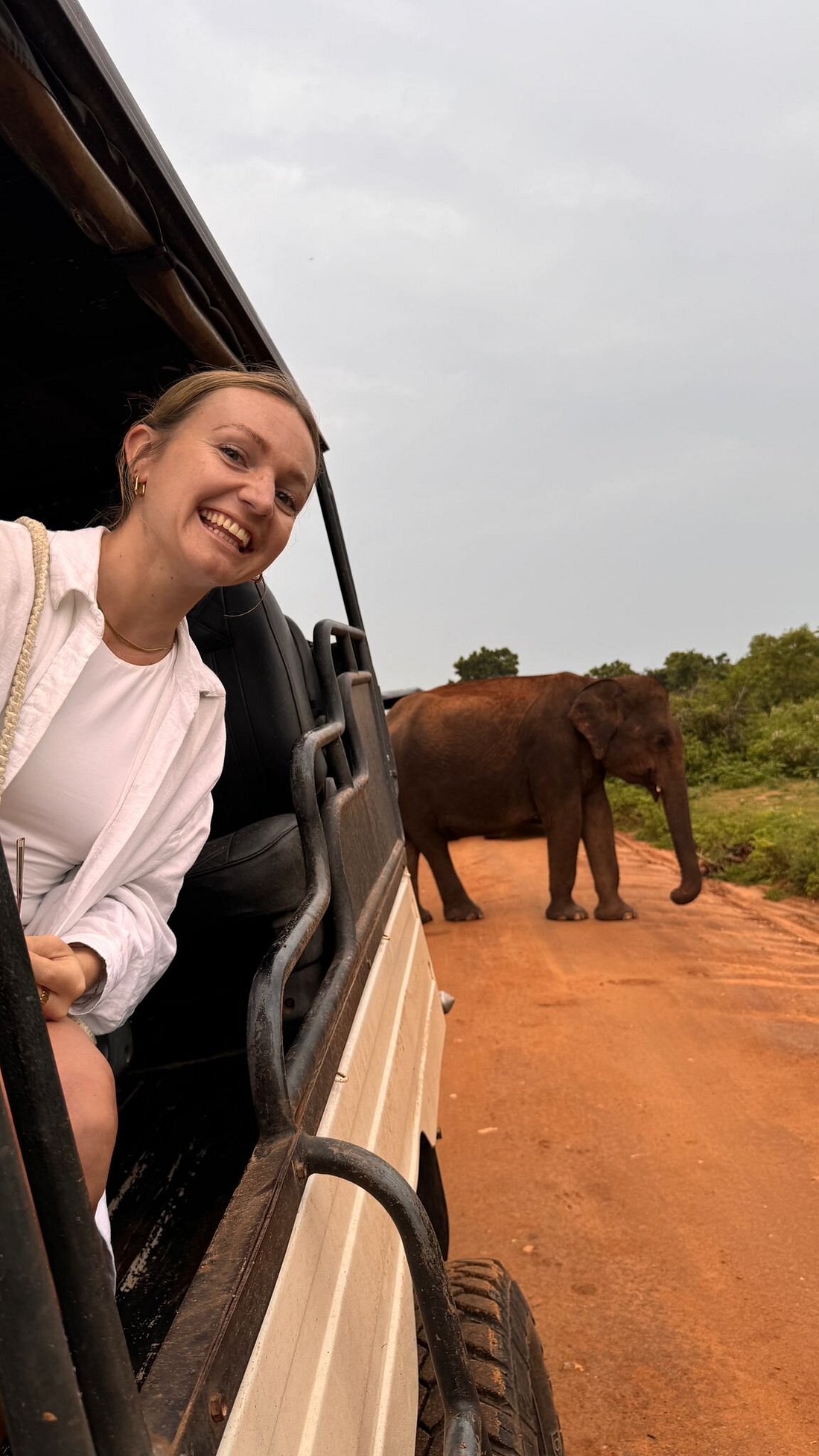 Traveller smiling as an elephant crosses the track